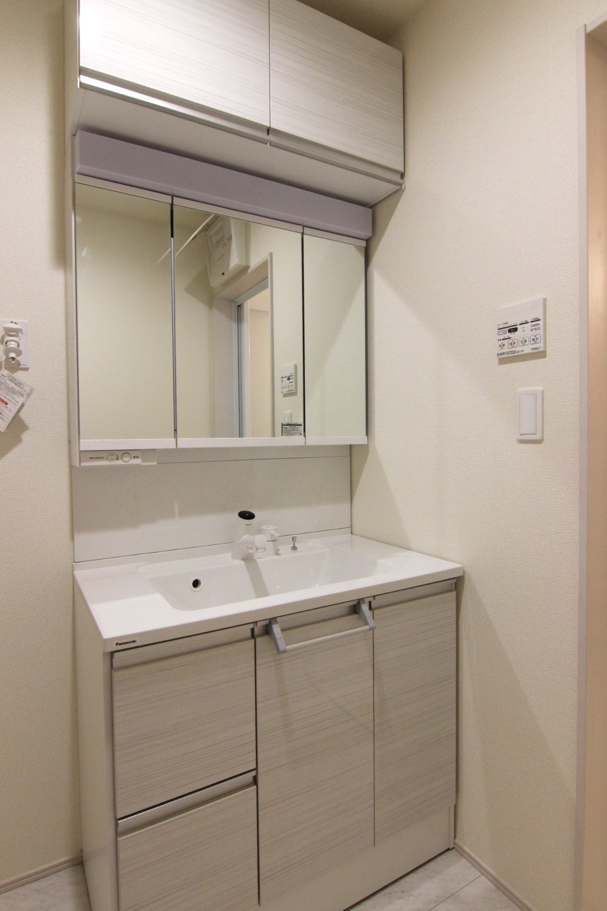 【3号棟:洗面台】　収納力に優れた3面鏡化粧台は、便利なタッチレス水栓で、三面鏡の裏にはコンセント付き収納スペース!中央の鏡は曇り止め仕様に。　※洗面台の仕様と床下収納は全棟共通です
