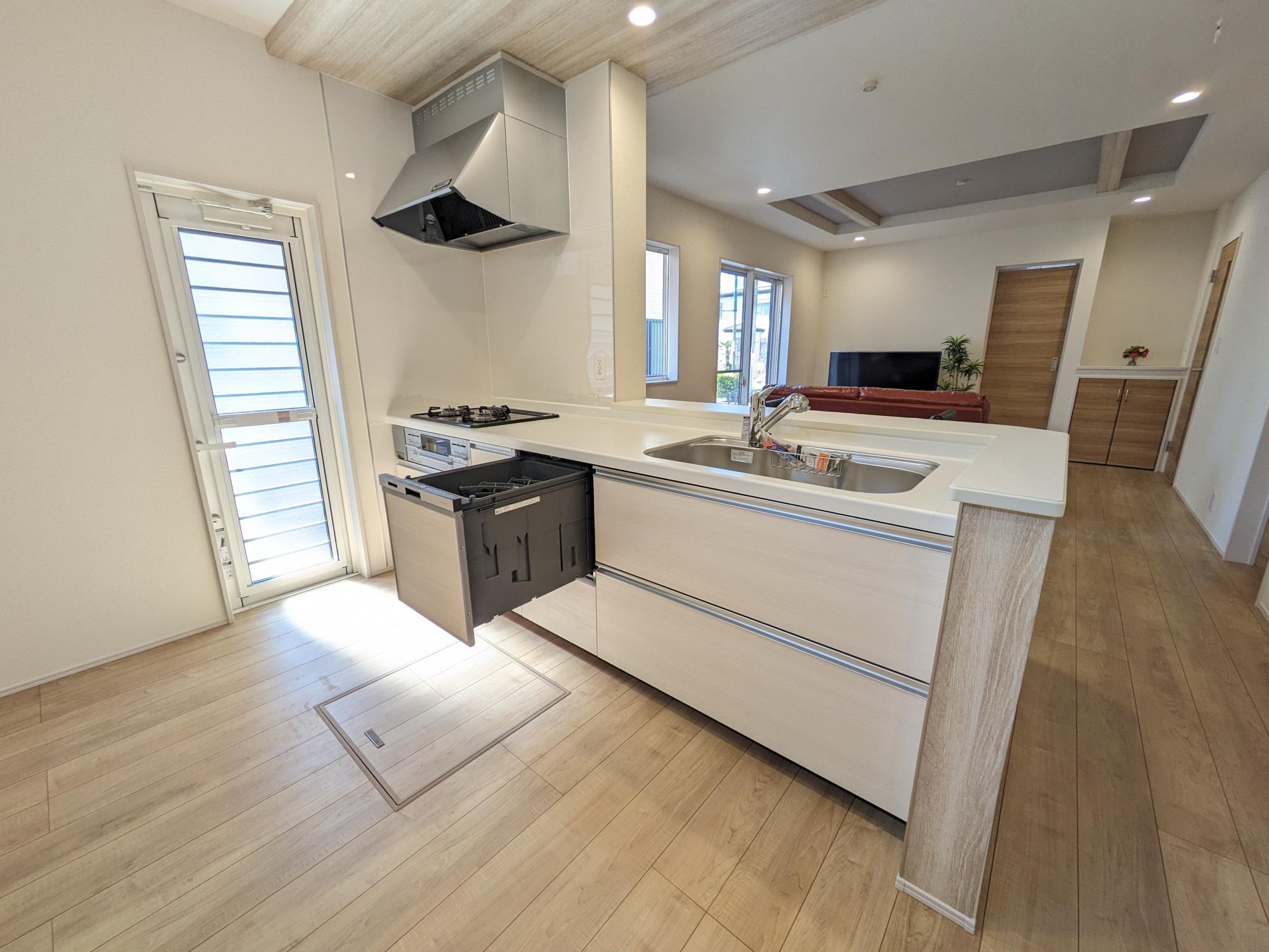 【2号棟】　解放感たっぷりのオープンキッチンは、スタイリッシュなレンジフードとポップアップ天井で洗練された空間に。食洗器標準装備で家事の時短にもなります。