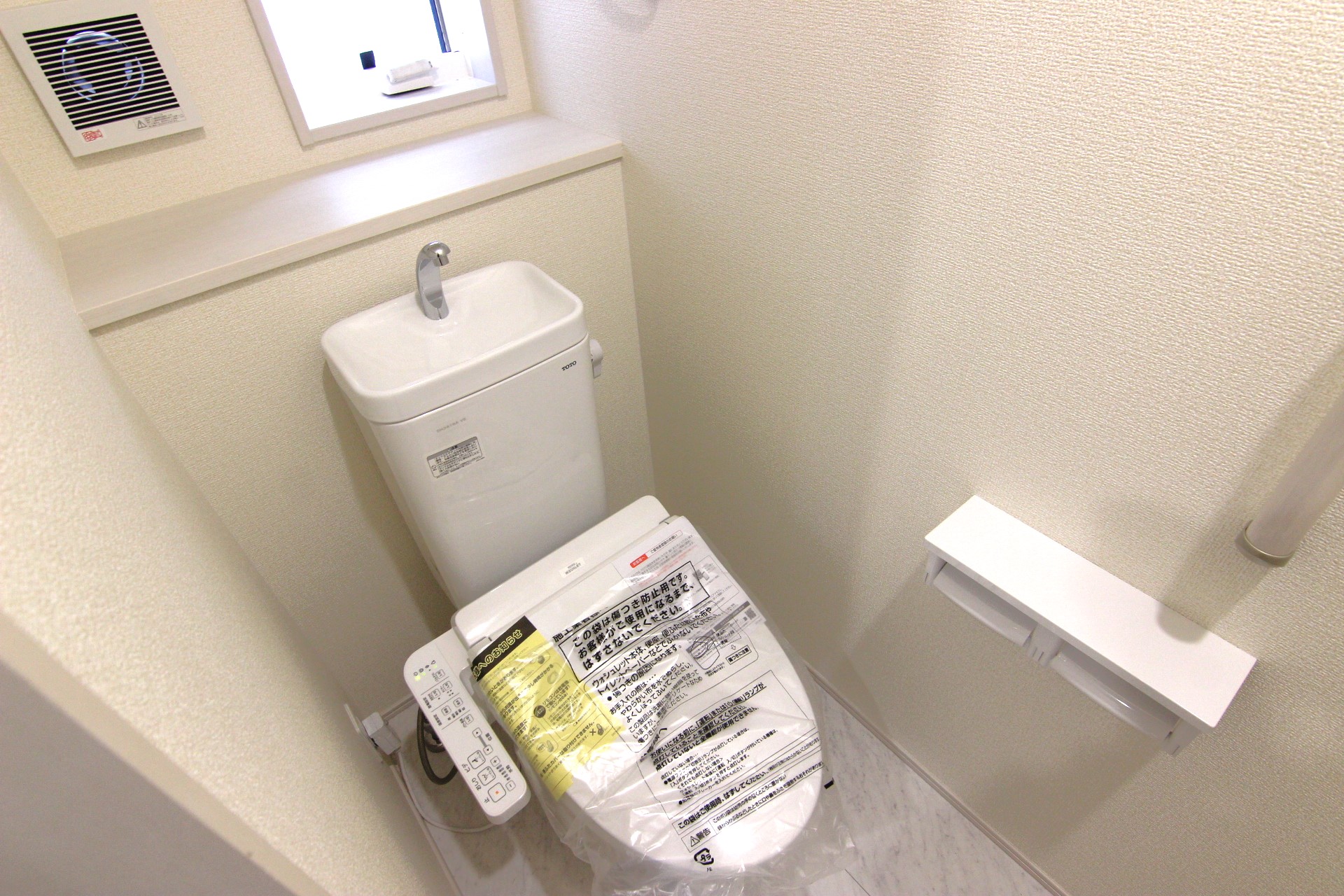 【1階トイレ:3号棟】　多機能ウォシュレット・手摺り・壁面収納付き・背面には小物が置けるカウンターも付いています。